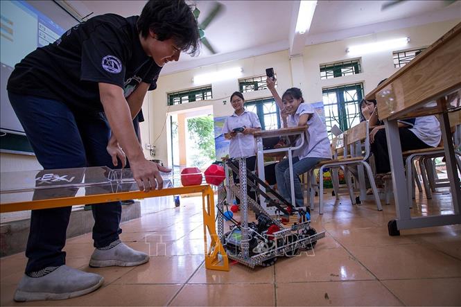 Các bạn học sinh trường Tiểu học &THCS Nhuận Trạch xã Lương Sơn hào hứng được trải nghiệm điều khiển Robot nhặt bóng và đưa bóng vào đường băng. (Ảnh: Trọng Đạt/TTXVN)